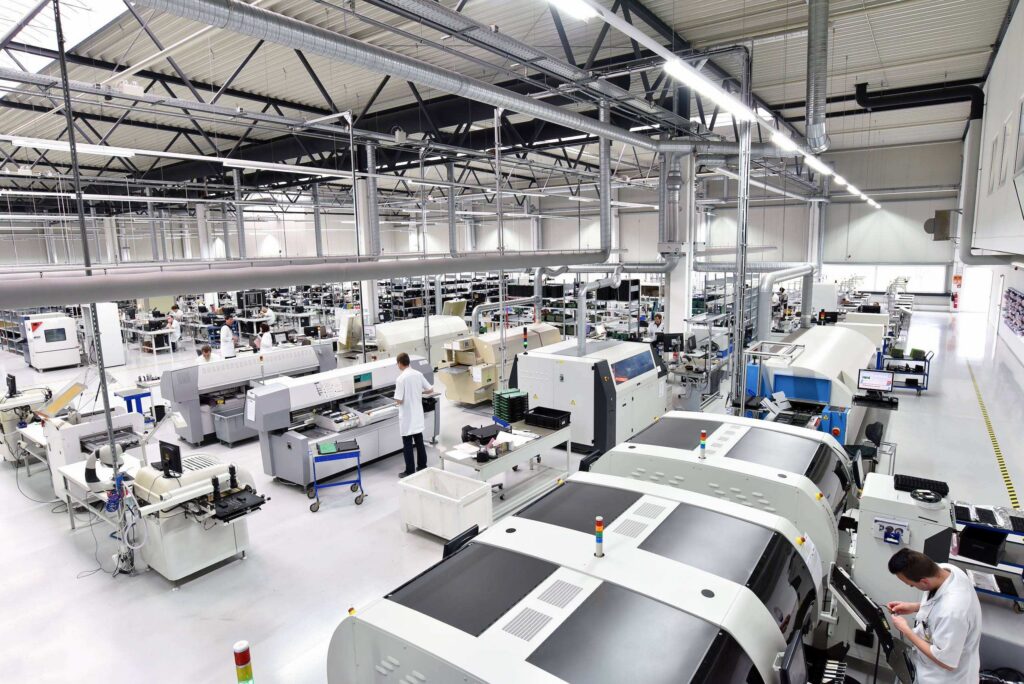 Produktionshalle mit Fertigungsanlagen und Mitarbeitenden